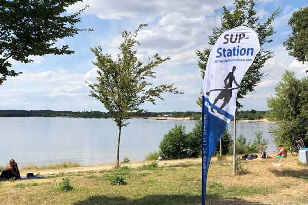 Ein Stand-Up-Paddling Aufsteller steht am Strand.